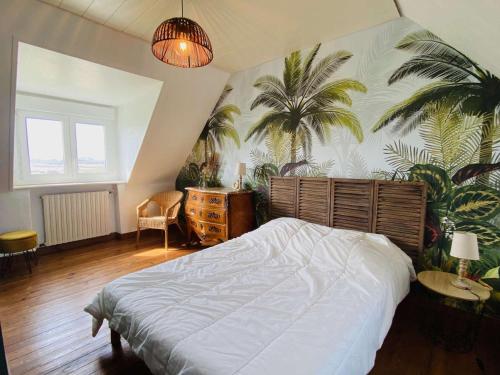 - une chambre avec un lit et des palmiers sur le mur dans l'établissement Maison bord de mer avec jardin et parking privé - FR-1-542-41, à Pleumeur-Bodou