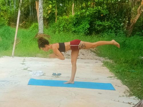 a woman doing a yoga pose on a blue mat at Angels' homestay Marari in Mararikulam