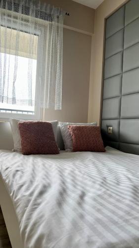 a large bed with two pillows and a window at Presto by Housine,pl Zator in Zator