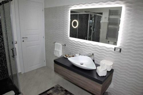 ein Bad mit einem Waschbecken und einem Spiegel in der Unterkunft Vampolieri luxury home in Aci Catena