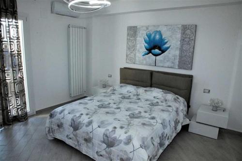 ein Schlafzimmer mit einem Bett mit einem blauen Blumengemälde an der Wand in der Unterkunft Vampolieri luxury home in Aci Catena