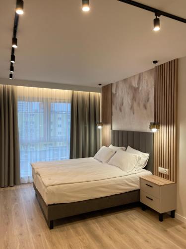 a bedroom with a large bed and a large window at Moris Boutique Beach Hotel in Gdańsk