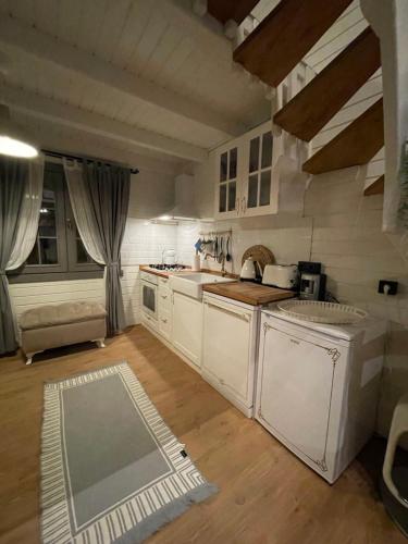 a kitchen with white appliances and a wooden floor at Egeos Lake House in Sakarya