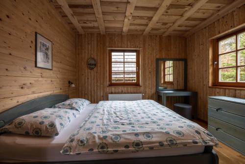 a bedroom with a bed in a wooden room at Apartments Brina in Bohinj
