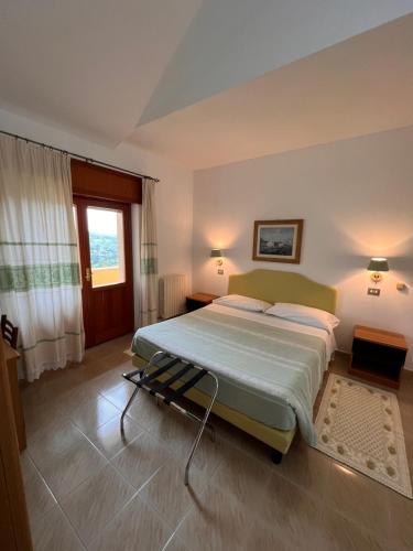 a bedroom with a large bed and a window at Hotel La Capannina in Aritzo