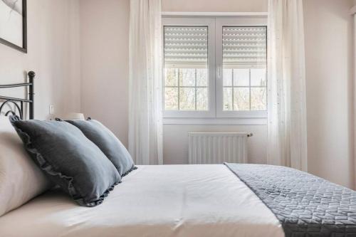a bedroom with a bed with pillows and a window at Unifamiliar Europa in Ciudad Real