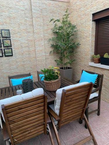 a patio with a wooden table with chairs and plants at Unifamiliar Europa in Ciudad Real