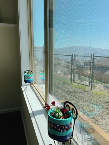 a window with two vases sitting on a window sill at Peaceful and Spacious Lake View in West Kelowna