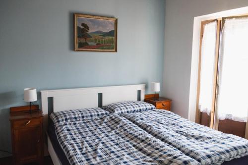 ein Schlafzimmer mit einem Bett mit einer karierten Decke in der Unterkunft Casa Celestino in Trarego Viggiona