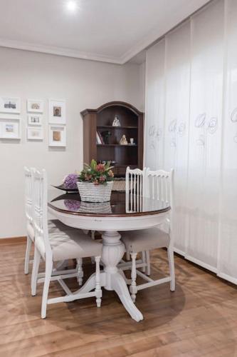 a dining room with a table and white chairs at Unifamiliar Europa in Ciudad Real