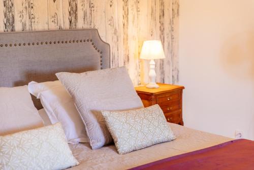 a bed with two pillows and a lamp on a night stand at MONTISMAURELLI in Montmoreau