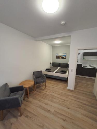 een kamer met een bed en twee stoelen en een tafel bij Hafen Appartements Wismar in Wismar