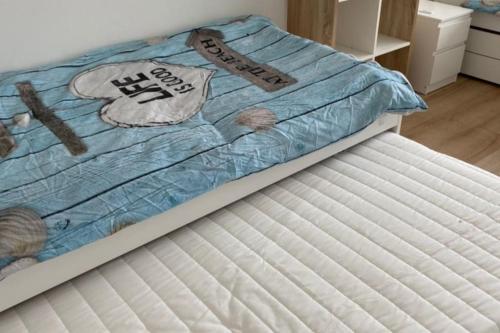 Una cama con un edredón azul y blanco. en Dom nad morzem, basen, plaża, siłownia, plac zabaw, kort tenisowy, en Ustronie Morskie