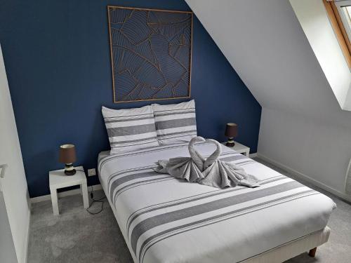 niebieska sypialnia z łóżkiem z łukiem w obiekcie Appartements Lannion proche centre, Côtes de Granit Rose w mieście Lannion