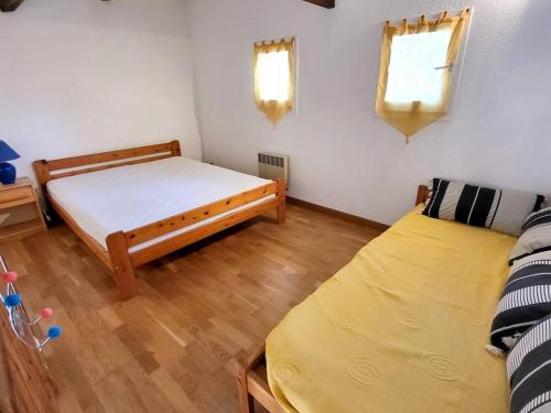 une chambre avec deux lits et un parquet dans l'établissement T3 Duplex à 200 m Plages/Commerces - Parking, Wi-Fi, Piscine, Tennis - Animaux Acceptés - FR-1-316-104, à Six-Fours-les-Plages