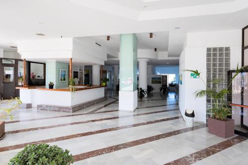a lobby with white columns and plants in a building at Ocean View Sunset in Adeje