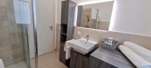 ein Bad mit einem Waschbecken und einem Spiegel in der Unterkunft Villa Gisira - Luxury SPA in Brucoli