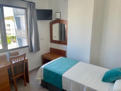 a bedroom with a bed and a desk and a window at Hotel Brisa Ibiza - Adults only in San Antonio
