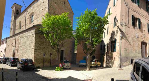 una calle con coches estacionados frente a un edificio en La Piazzetta en Serra San Quirico