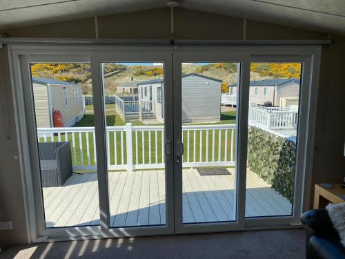 an open sliding glass door with a deck at Covesea View in Lossiemouth