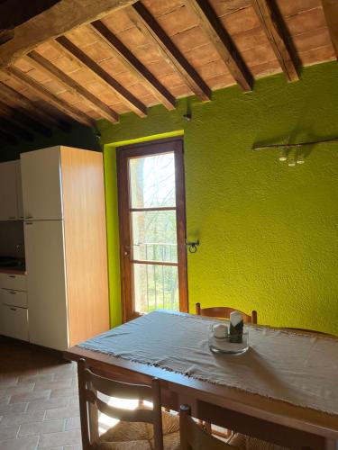 a kitchen with a table and a green wall at Agriturismo Monte Gusciani in Massa Marittima