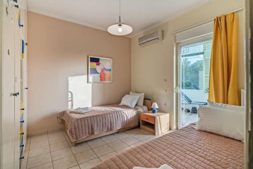 a bedroom with a bed and a window at Chryssi Akti Sea View 1 min (100m) from the beach in Daratso