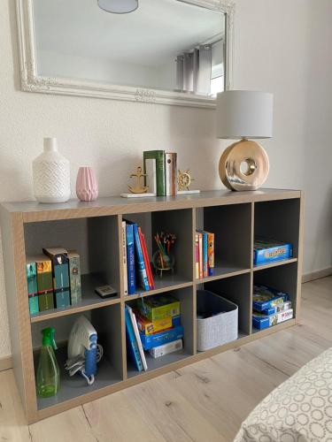 ein Bücherregal mit Büchern und einer Lampe in einem Zimmer in der Unterkunft Zentrales City Penthouse in Friedrichshafen