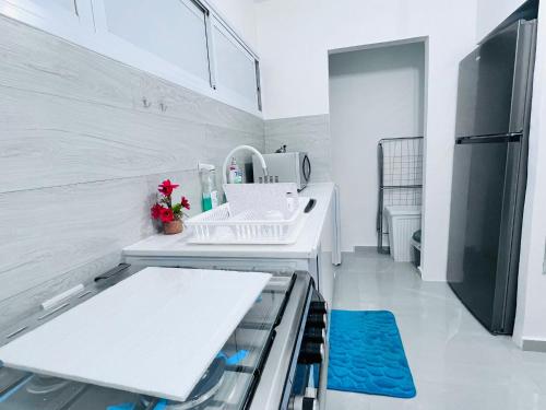 La cuisine blanche est équipée d'un évier et d'un réfrigérateur. dans l'établissement New! Your home in Israel Luxury Suite, à Bat Yam