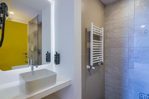 W łazience znajduje się umywalka i prysznic. w obiekcie Ibis Styles Bucharest Airport w mieście Otopeni