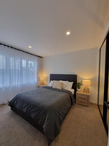 Un dormitorio con una cama grande y una ventana en Inner City 2 Bedroom Unit en Hamilton