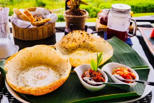 a plate of food on a banana leaf with food at Hotel SunSet 