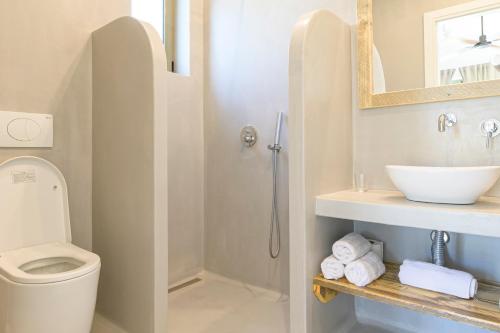 a bathroom with a shower and a toilet and a sink at LOGOS Beach Village in Theologos