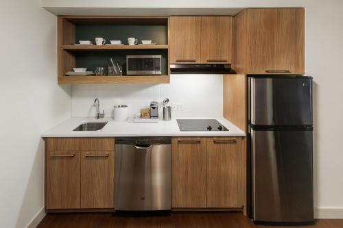 a kitchen with a sink and a refrigerator at Element Detroit at the Metropolitan in Detroit