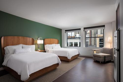 duas camas num quarto de hotel com duas janelas em Element Detroit at the Metropolitan em Detroit