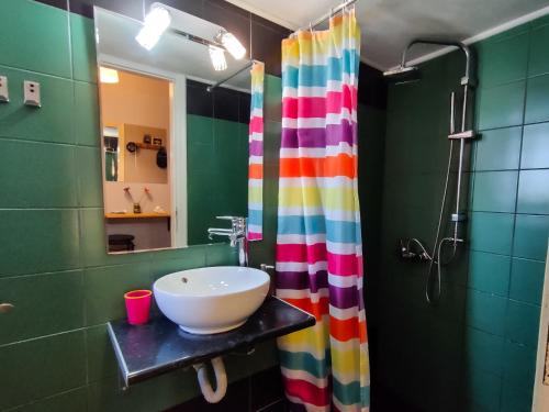 a bathroom with a sink and a colorful shower curtain at Studio in Athens center in Athens