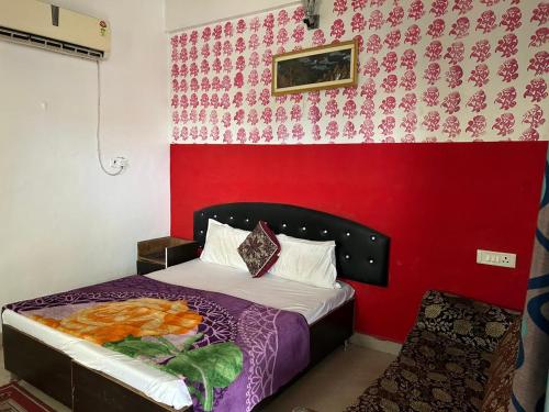 a bedroom with a bed with a red wall at Hotel Blue Star in Haldwāni