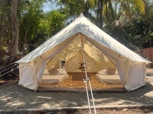 une tente en toile avec 2 lits dans l'établissement INNBOX CAMPSITE, à Bolinao