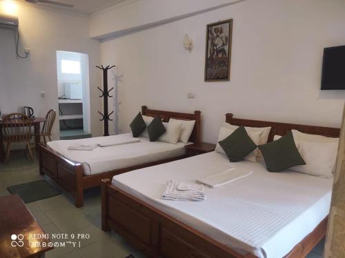 a bedroom with two beds and a dining room at Oasis Beach Resort in Negombo