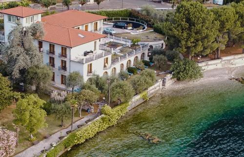 una vista aérea de una casa junto a un cuerpo de agua en Hotel Villa Maria Au Lac - Estella Hotels Italia, en Toscolano Maderno