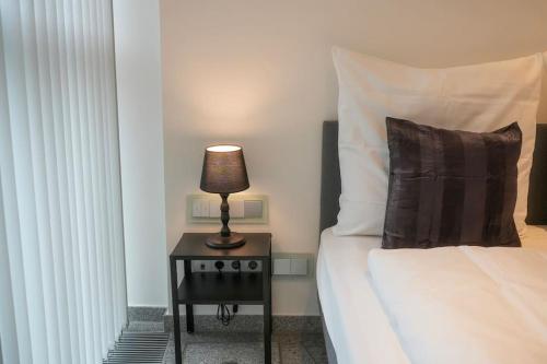ein Schlafzimmer mit einem Bett und einer Lampe auf einem Tisch in der Unterkunft Exklusive Stadtoase Design·Wohnung · Panoramablick in Koblenz