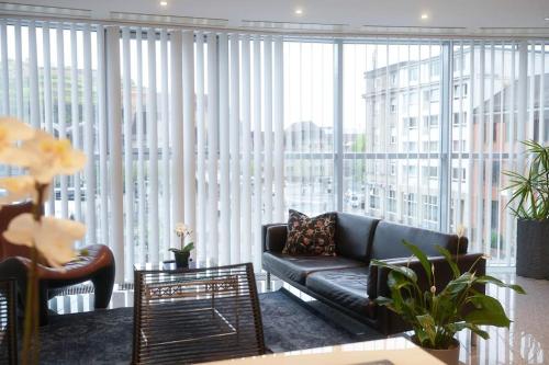 ein Wohnzimmer mit Couch und großem Fenster in der Unterkunft Exklusive Stadtoase Design·Wohnung · Panoramablick in Koblenz