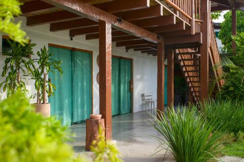 a porch of a house with green doors and plants at Tropical Beach in Porto Seguro