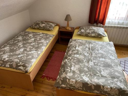 two beds in a small room with a lamp at Guest House Kevser in Sarajevo