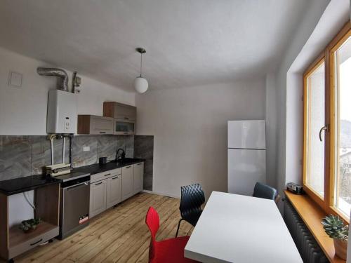 a kitchen with a table and a white counter top at Evergreen Condo in Braşov