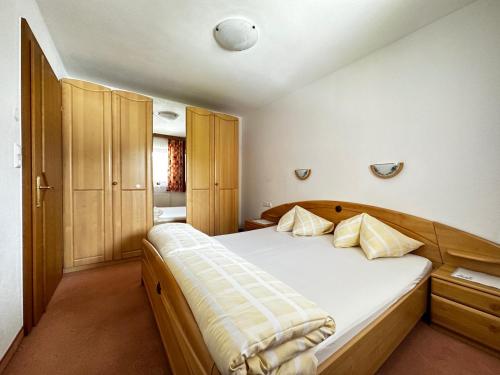 1 dormitorio con 1 cama blanca grande y armarios de madera en Haus Luxer, en Auffach