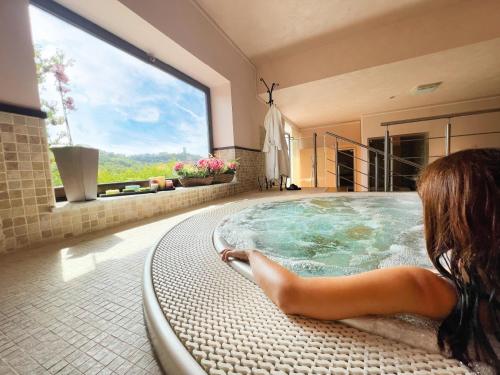 a woman sitting in a hot tub in a bathroom at Iscairia Country House in Ascea