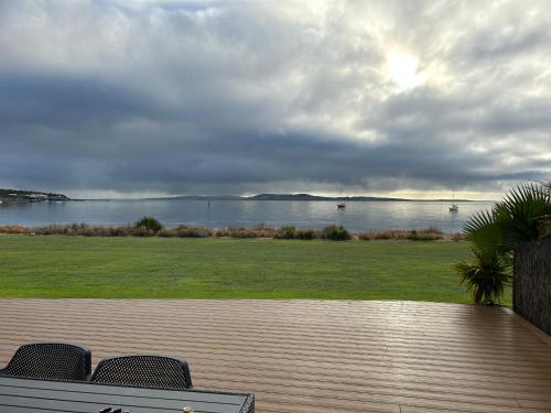 a deck with chairs and a view of the water at Kiana Beach House in Port Lincoln