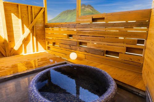 a room with a large tub in a room with a window at Misora Yufuin - Vacation villa with private hot spring in Yufu