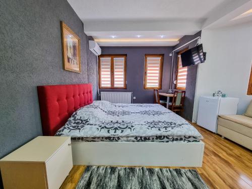 a bedroom with a large bed with a red headboard at Gurman in Strumica