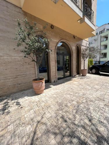 a building with a potted tree in front of it at Park Hotel Sandanski in Sandanski